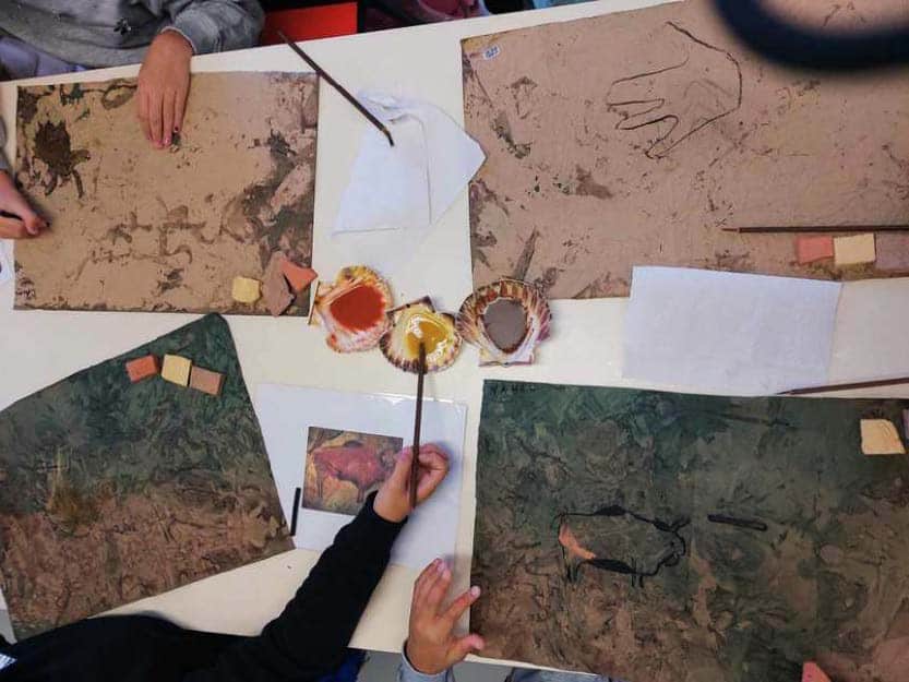Enfants réalisant des peintures inspirées de l’art pariétal avec pigments naturels lors d’un atelier à Sainte-Lucie de Porto-Vecchio.
